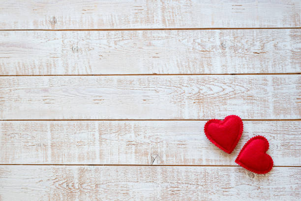 istock Valentines Day background with hearts over white wooden table 899976708