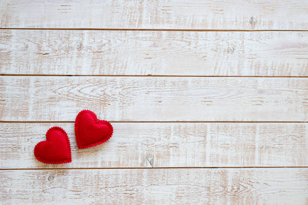 istock Valentines Day background with hearts over white wooden table 899977060