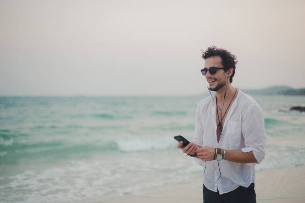 istock Listening music on the beach 899987596