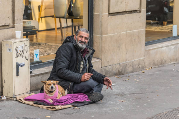 Homeless man sitting on the street stock photo