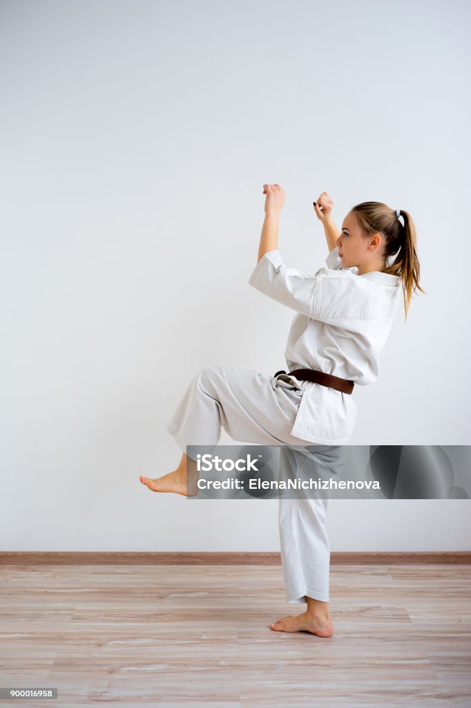 Karate girl training A portrait of a karate girl training Kicking Stock Photo