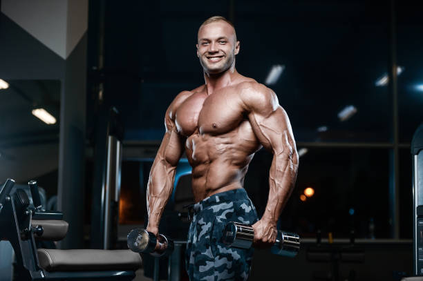 istock Brutal strong bodybuilder athletic men pumping up muscles with dumbbells 900036206