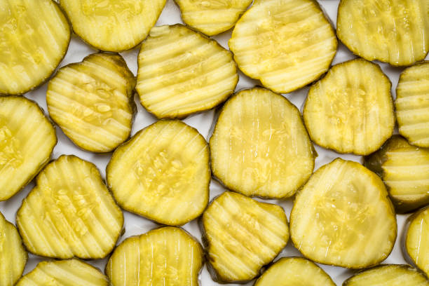 slices of cucumber pickles slices of cucumber pickles - background on a white plate pickled stock pictures, royalty-free photos & images