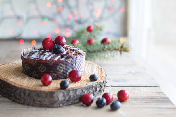Christmas Cake with nuts and berries on rustic background.