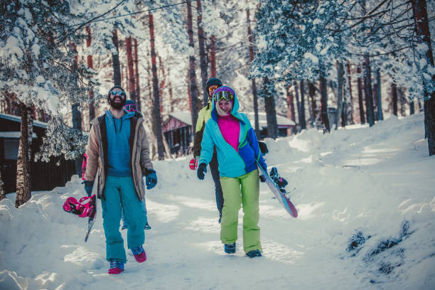 istock Snowboarders on snowy mountain and pine tree woodland 900058356