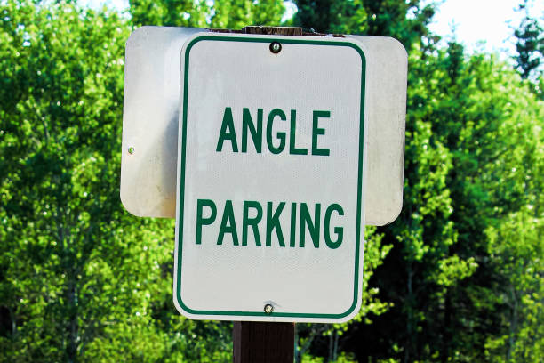 istock A green angle parking sign with trees in the background 900071236