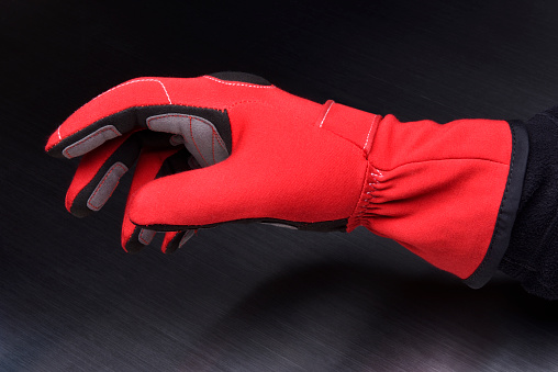 Red gloves for motorsport racing on a dark background