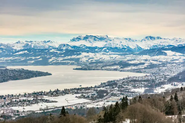 Lake Zurich, summits of the Alps - a wintertime view from Mt. Uetliberg. The Uetliberg is a mountain rising to 870 m, it offers a panoramic view of the entire city of Zurich and the Lake Zurich.