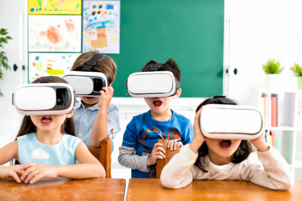 überrascht studenten mit virtual-reality-kopfhörer im klassenzimmer - junior school stock-fotos und bilder