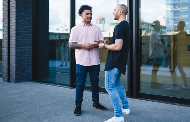 istock Two work colleagues talking outside the office building. 900078262