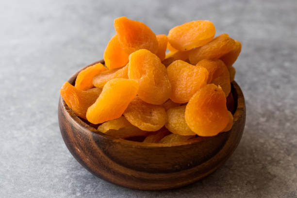istock Dried Apricots in wooden Bowl. 900093670