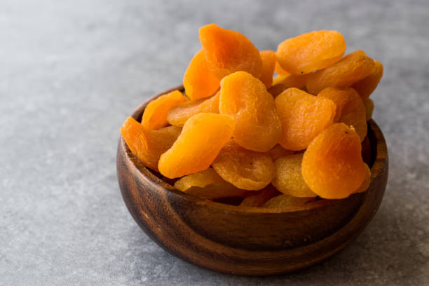 istock Dried Apricots in wooden Bowl. 900097106