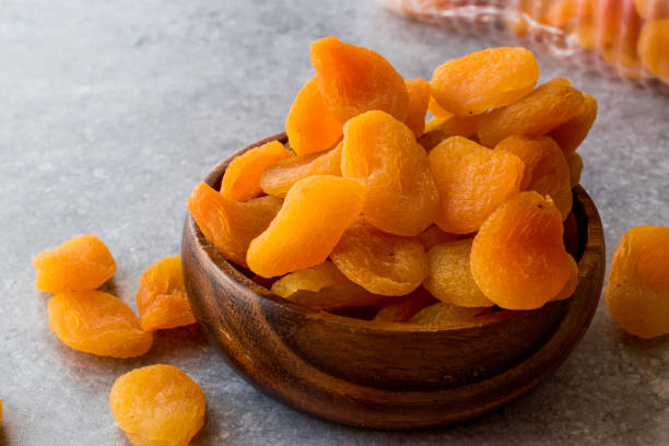 istock Dried Apricots in wooden Bowl. 900097686