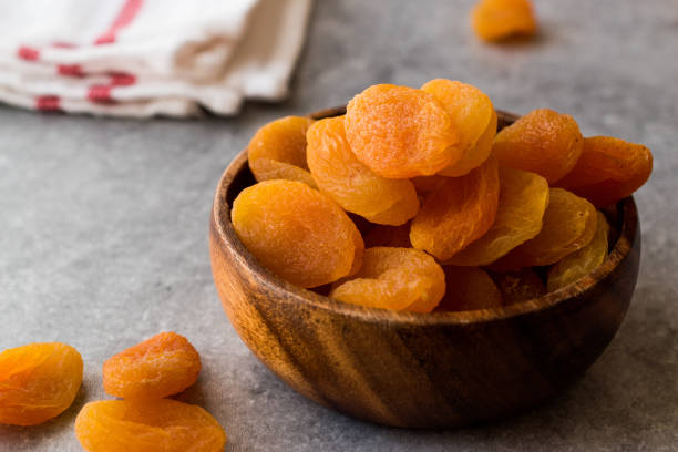 istock Dried Apricots in wooden Bowl. 900100154
