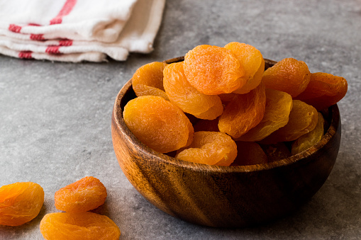 Dried Apricots in wooden Bowl. Organic Food.