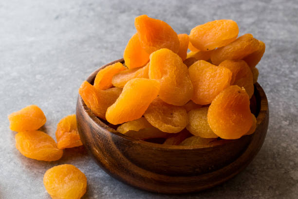 istock Dried Apricots in wooden Bowl. 900104024