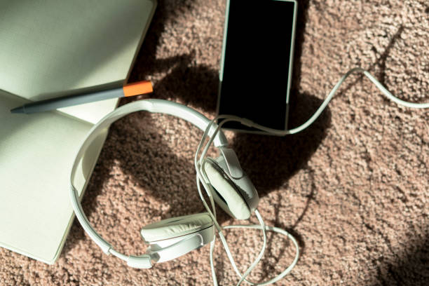istock smart phone, headphones and notebook on carpet 900107078