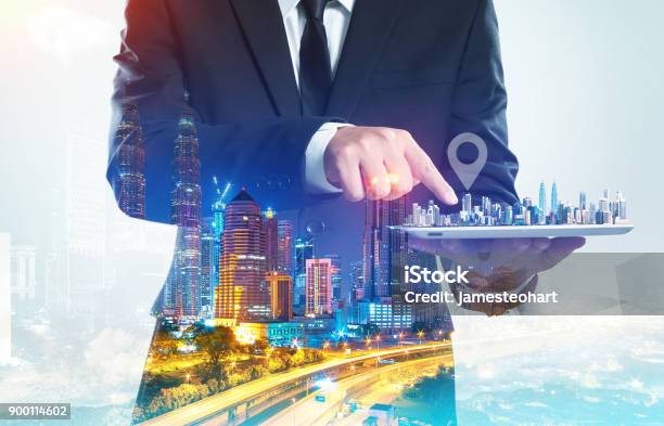 Success Businessman Using Digital Tablet Show The Home On Virtual Screen With Night Cityscape Double Exposure Effect Stock Photo - Download Image Now