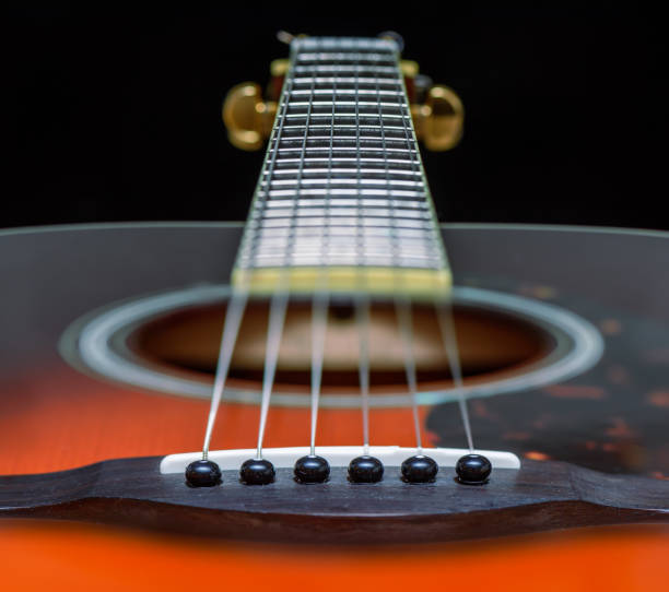 istock Acoustic orange guitar with strings close-up 900115836