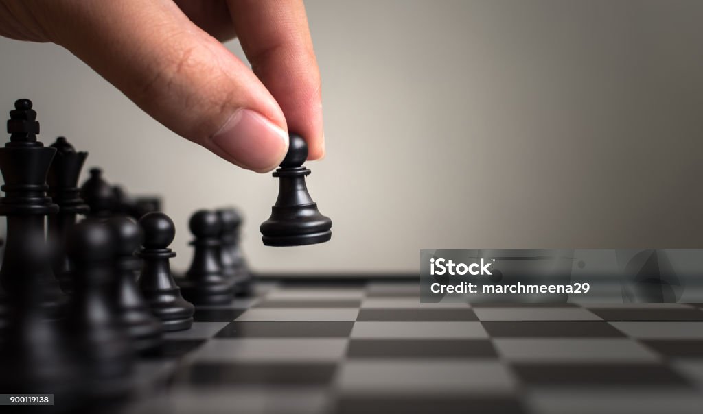 Plan leading strategy of successful business leader concept, Hand of player chess board game putting black pawn, Copy space for your text Strategy Stock Photo
