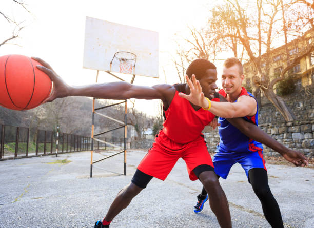istock Basketball players playing outdoors on court 900119884