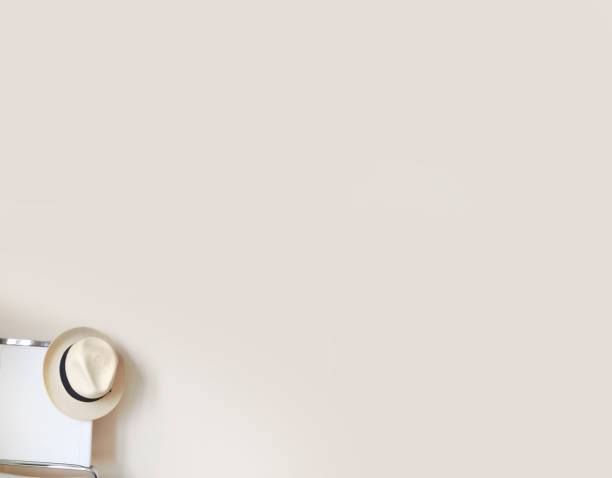 istock White wall background with white chair and straw hat on the left 900130020