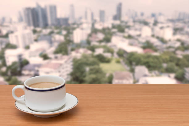 istock coffee on wooden table with buildings blur background 900134624
