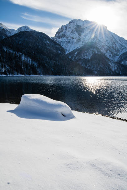 schönen winter verschneite landschaft reflexion über see lago del predil mit isolierten schneebedeckten felsen in den julischen alpen, italien - julian alps mountain lake reflection stock-fotos und bilder