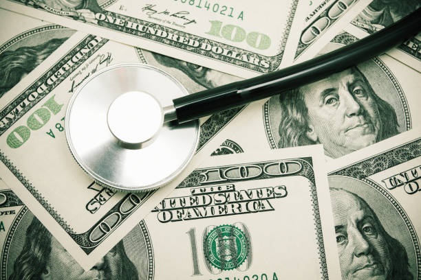 stetoscopio su sfondo valuta cartacea usa - currency stethoscope healthcare and medicine savings foto e immagini stock