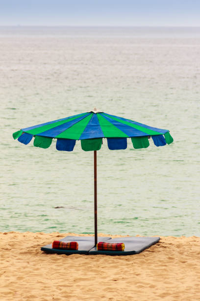 istock Beautiful sandy beach with umbrella, mattress and pillow 900168838