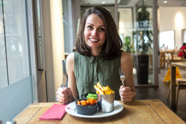 istock Young woman having lunch in restaurant 900171924
