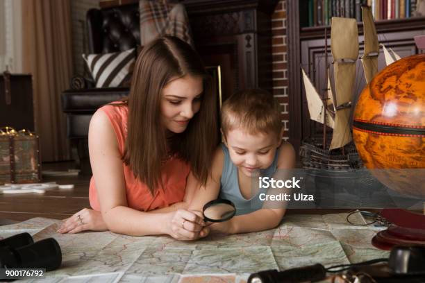 Family Mother And The Little Son Study The Map And Choose A Route Of Travel Family Having Fun At Home Travel And Adventure Concept Stock Photo - Download Image Now