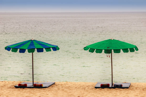 istock Beautiful sandy beach with umbrella, mattress and pillow 900179836