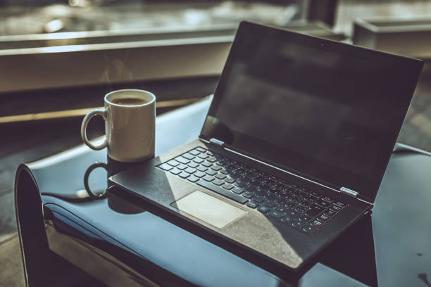 Morning cup of coffee and working space with laptop.
