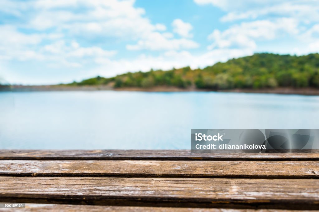 Vue proche d’une vieille table en bois. Lac bleu et le ciel en arrière-plan. - Photo de Lac libre de droits