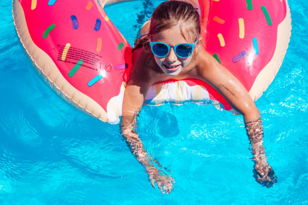 istock Girl on inflatable ring in swimming pool 900198656