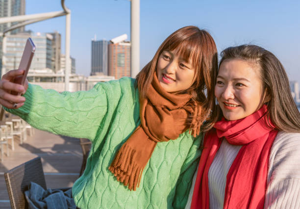 istock Young women take selfies with their mobile phones 900200060