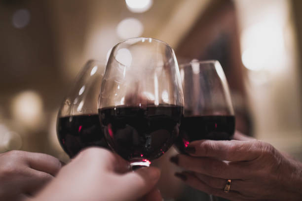 istock Four mature persons cheering with each a glass of red wine. 900200086