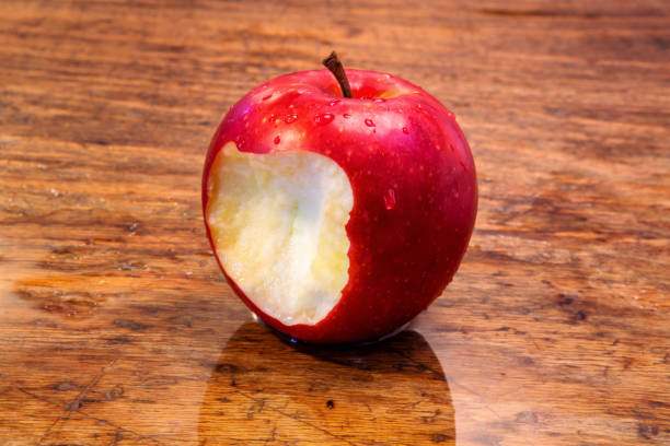 istock red wet apple with a bite on rustic wooden table 900207034