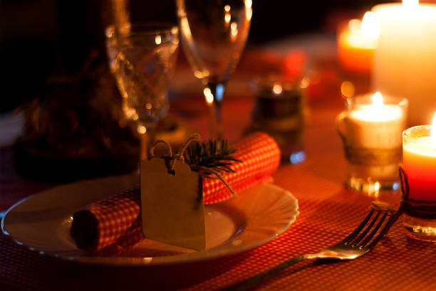 istock Festive composition with candles and plates. Table decoration. A beautiful table setting, red table cloth, tablecloth in the box. Christmas dinner. A white plate with a nice napkin on the table 900207090