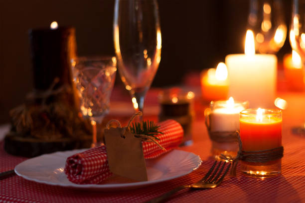 istock Festive composition with candles and plates. Table decoration. A beautiful table setting, red table cloth, tablecloth in the box. Christmas dinner. A white plate with a nice napkin on the table 900207146