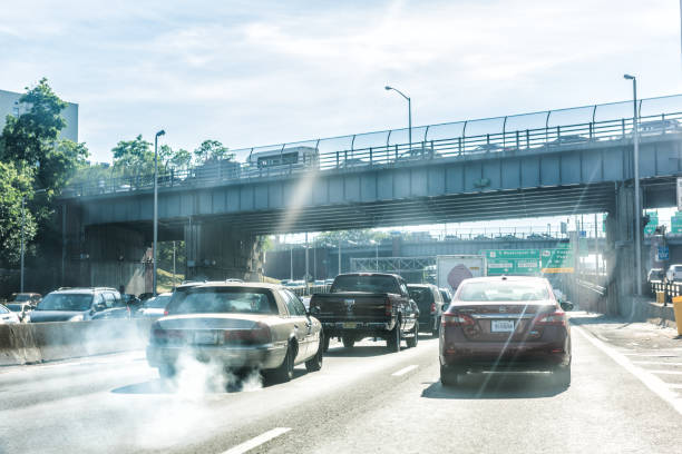 Road and street highway in NYC with sign for George Washington Bridge, smoke coming out of exhaust pipe of car New York City: Road and street highway in NYC with sign for George Washington Bridge, smoke coming out of exhaust pipe of car smog car stock pictures, royalty-free photos & images