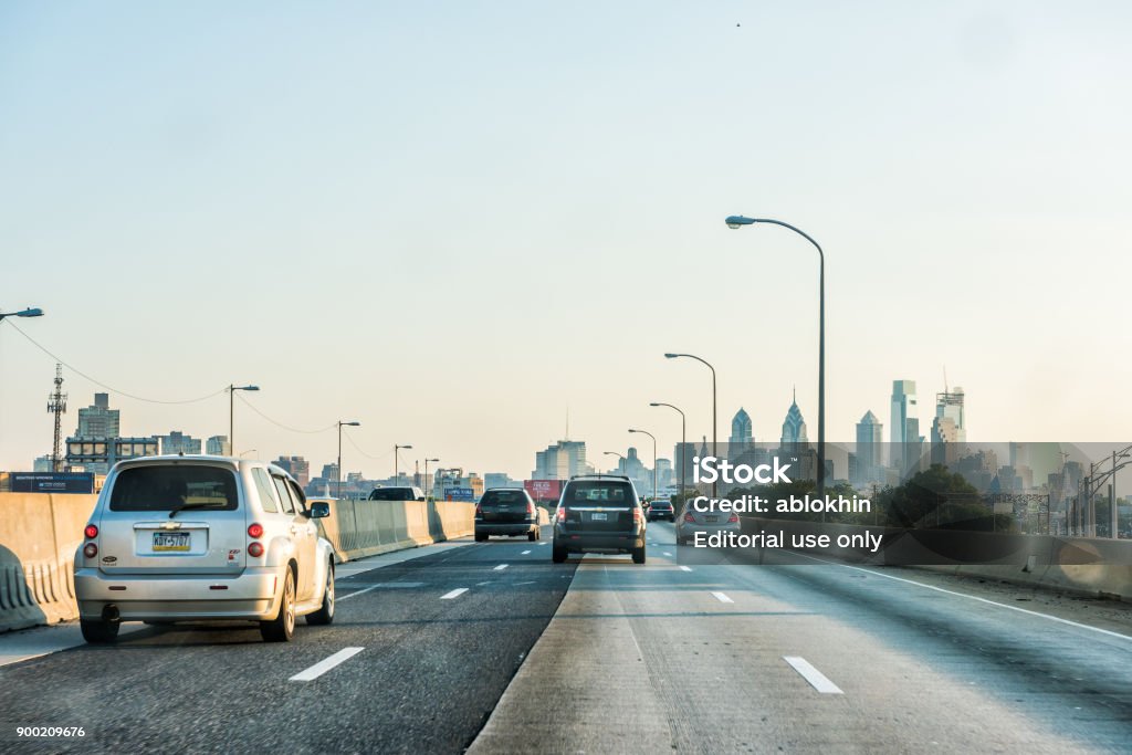 Carretera calle carretera en Pennsylvania con muchos coches en tráfico, vista al paisaje urbano del horizonte urbano de la ciudad al atardecer - Foto de stock de Coche libre de derechos