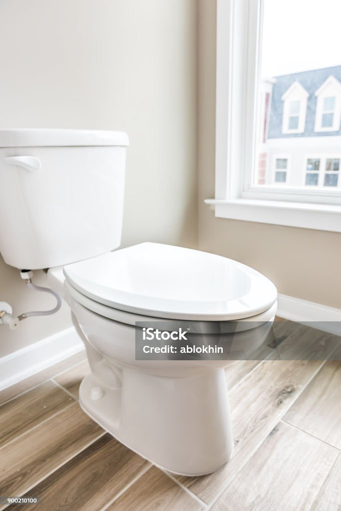 Minimalist modern clean white toilet in restroom with window in model house, home or apartment Toilet Stock Photo