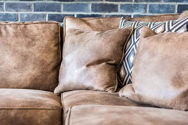 Elegant modern room closeup of leather couch by brick wall in staging model house or apartment