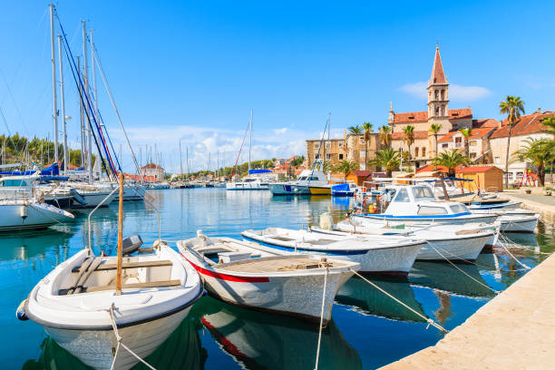 Fishing boats and view of beautiful church in Milna port on sunny summer day, Brac island, Croatia Dalmatia is a narrow belt of the east shore of the Adriatic Sea, stretching from island of Rab in the north to the Bay of Kotor in the south. brac island stock pictures, royalty-free photos & images