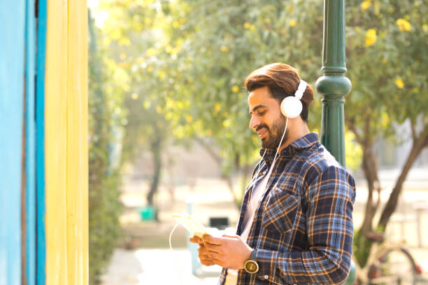 istock Happy young man using digital tablet and headphones 900243762