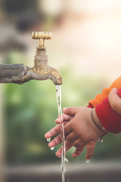 istock Stream of clean water pouring into infant hands. 900265338