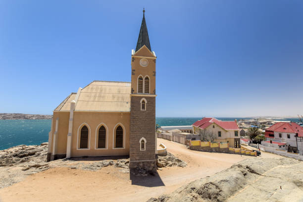 bela vista panorâmica da igreja colonial alemão protestante felsenkirche em lüderitz / luderitz, na namíbia, áfrica. partes da cidade em segundo plano. - luderitz city - fotografias e filmes do acervo