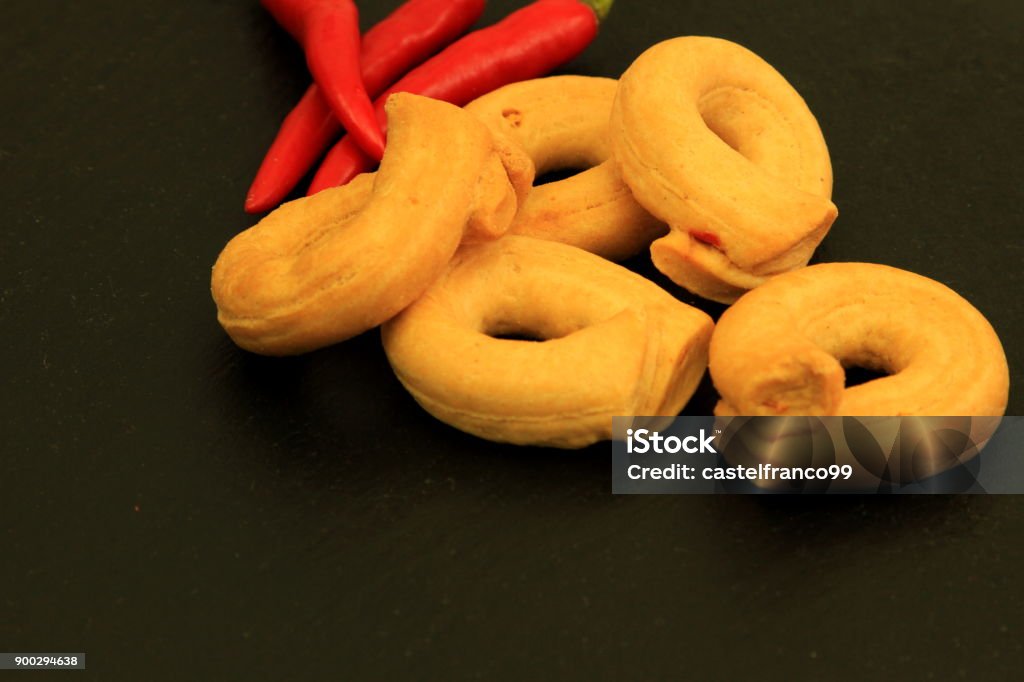 Italian tarallini with red pepper Italian snack tarallini with red hot chili pepper on slate background Aperitif Stock Photo